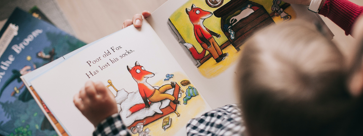 Child is getting a book read by adoptive parent